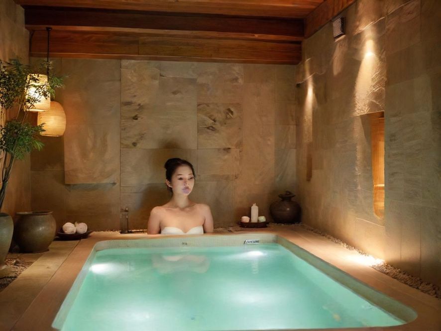 一位专业的按摩师在舒适的SPA房间内，手法娴熟地为客人进行按摩。